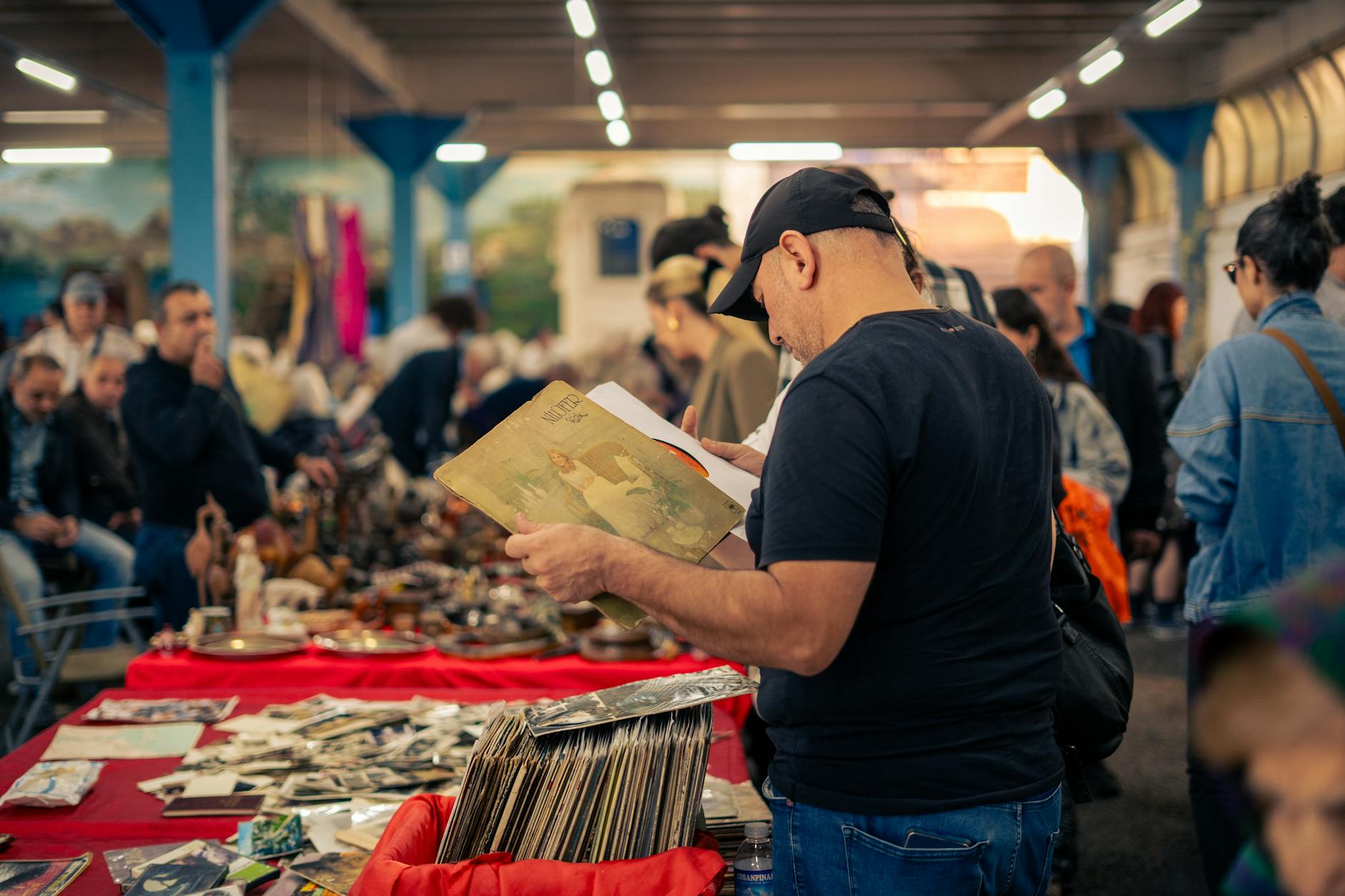 man in cap among people in bazaar